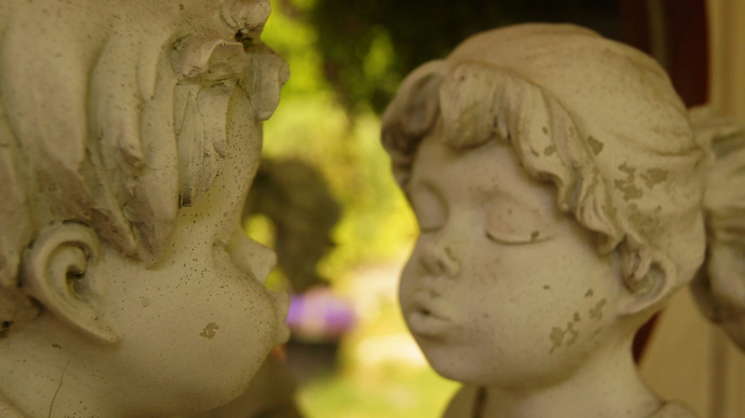 an old fashioned statues of children, each have their faces pressed in front of them