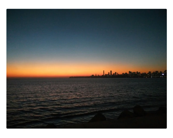 a body of water at night with a skyline in the background