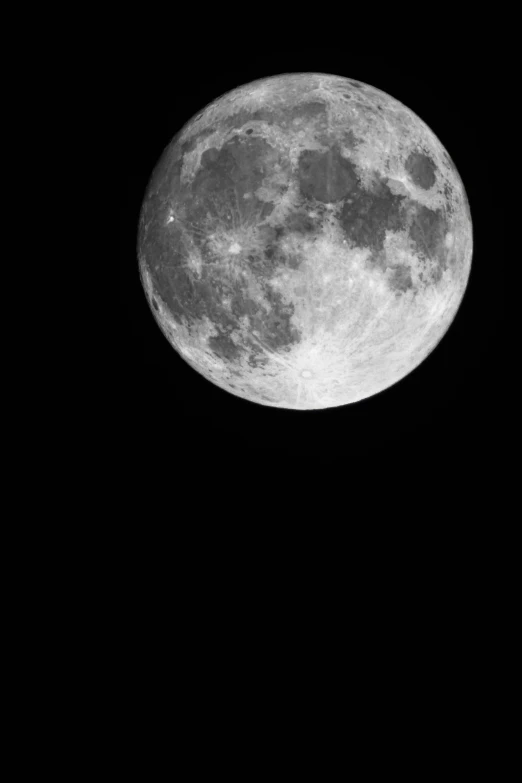 a large moon in the night sky above a dark background