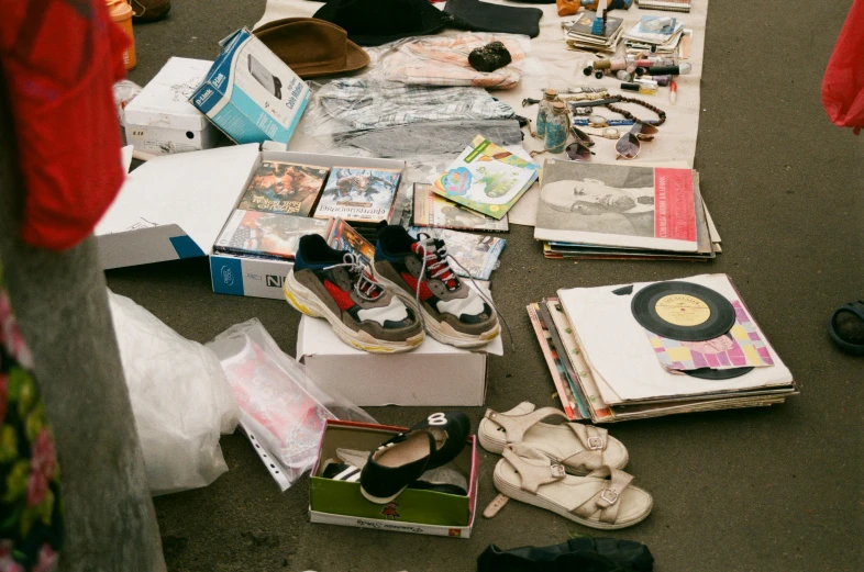 a street vendor sitting in front of his goods on the sidewalk