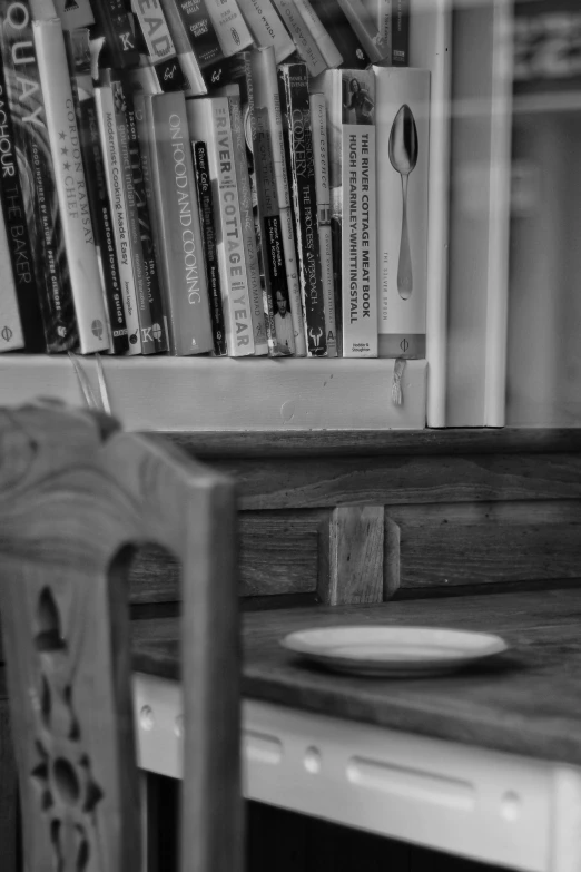 the book shelf is full of books and a bowl on the counter