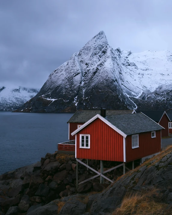 the water and mountains surround houses on a shore