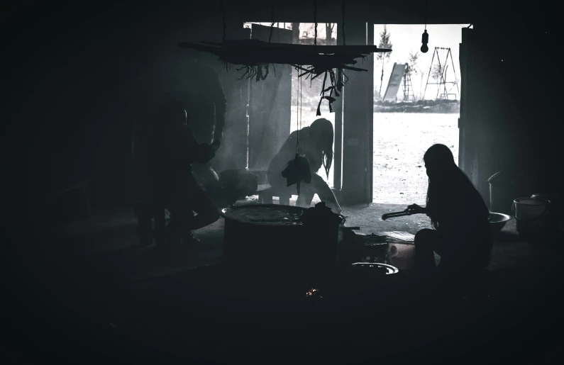 a silhouette of a woman in a dark room cooking