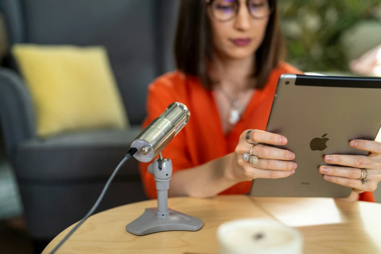 woman in red shirt and headphones holding an ipad