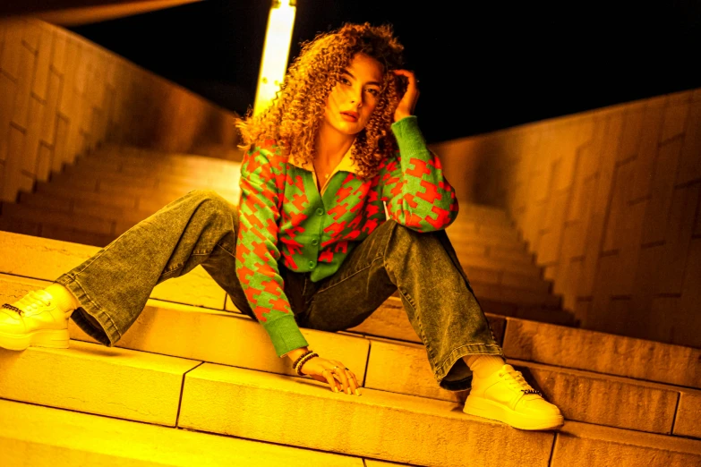 a woman sitting on some stairs at night