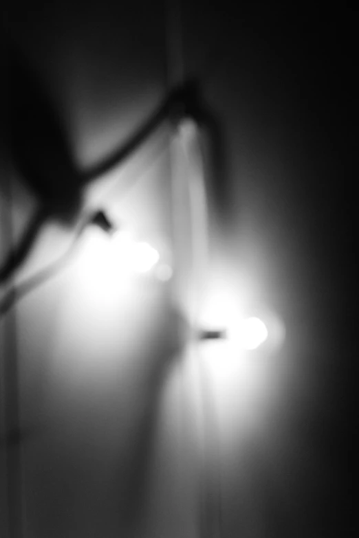 black and white pograph of two lights on the side of a wall