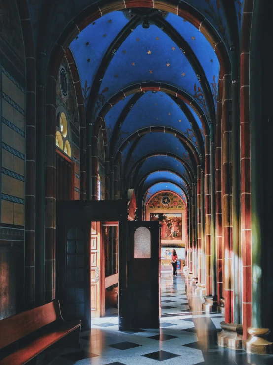 the inside of a large building with two benches and arched ceiling