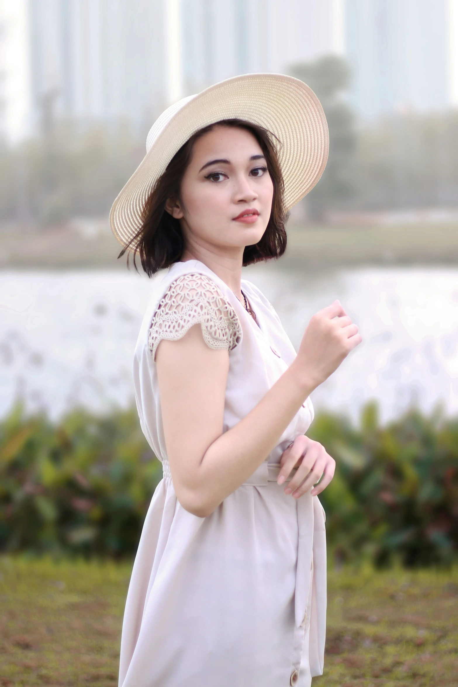 a woman with hat and dress holding a hand bag