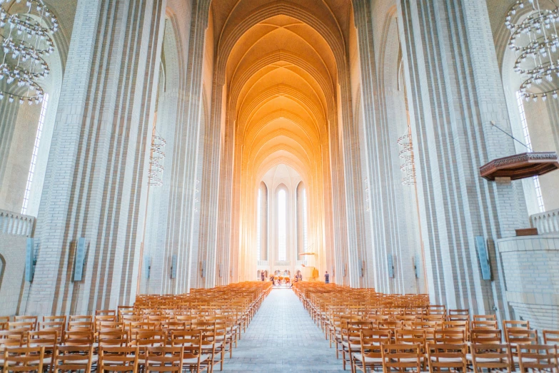 an empty cathedral filled with rows of wooden chairs