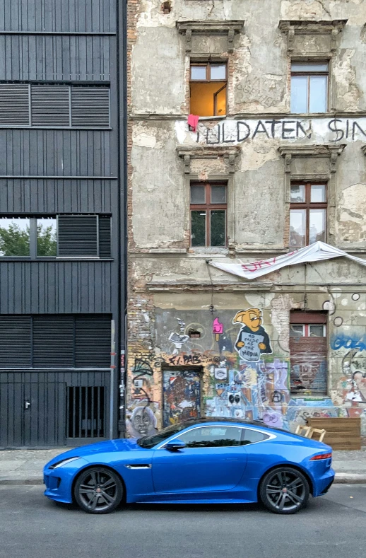 a car parked next to the building that has murals