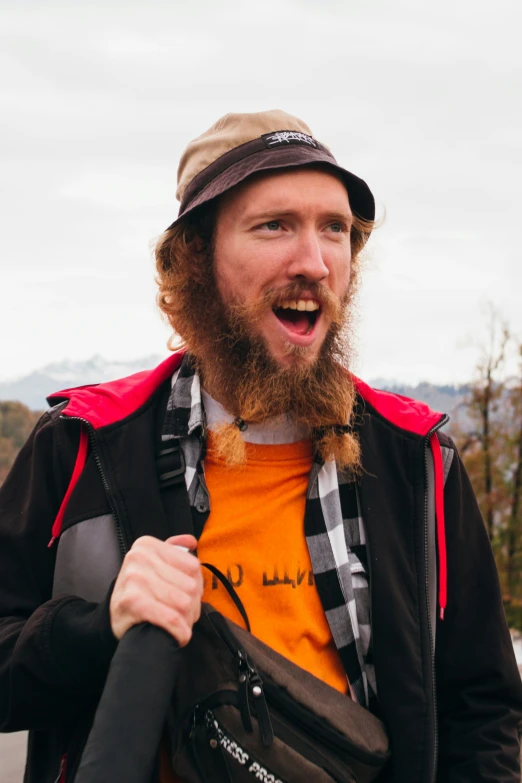 man with a backpack and hat making funny faces