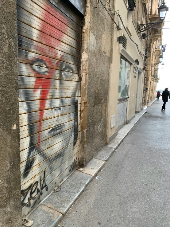 an artistic painted on a building next to a narrow road