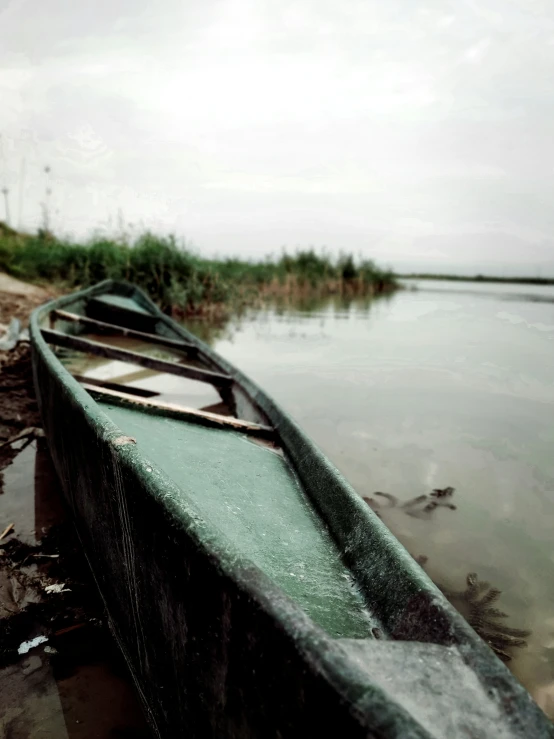 an empty boat sitting in shallow water on a beach