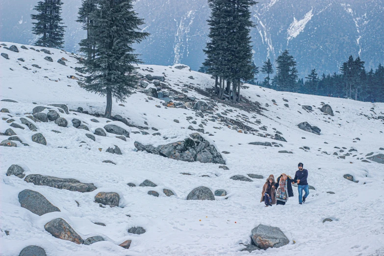 two people walk up the side of a mountain holding hands