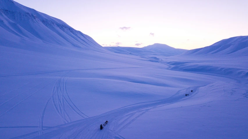 two people are trekking up and down a snowy mountain