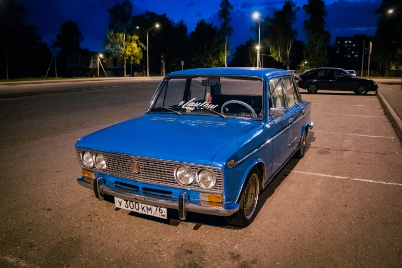 a blue car is parked in the middle of a parking lot