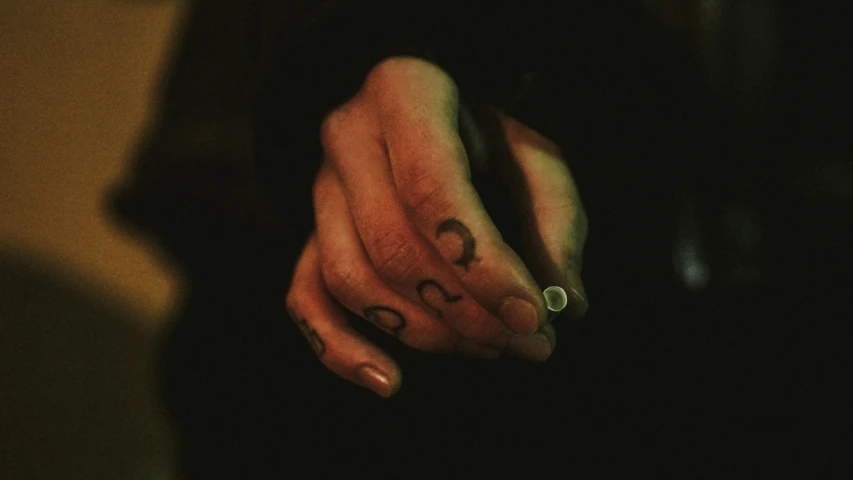 a close up of a person's finger with a finger tattoo