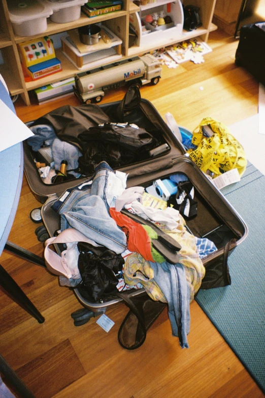 an open suitcase full of clothes on a floor