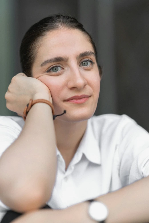 a woman is smiling with her arm on the table