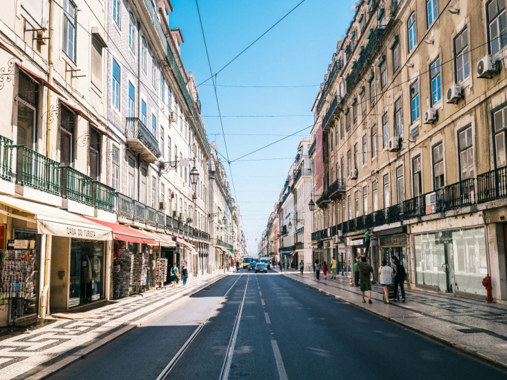 an empty street with people walking by and buildings