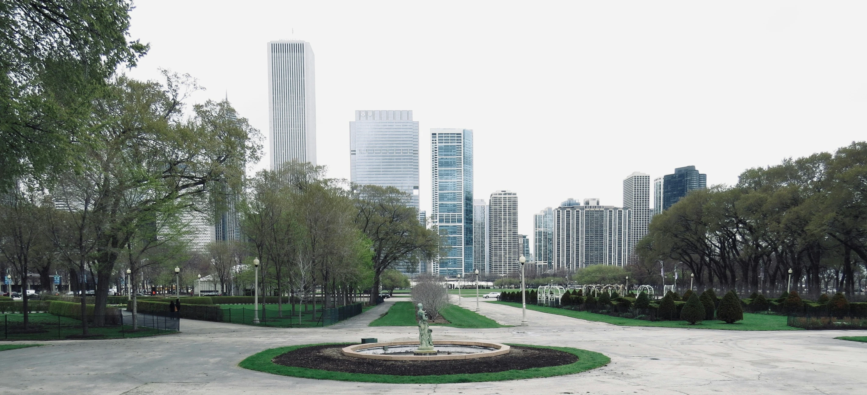 a view of city park with tall buildings in the background