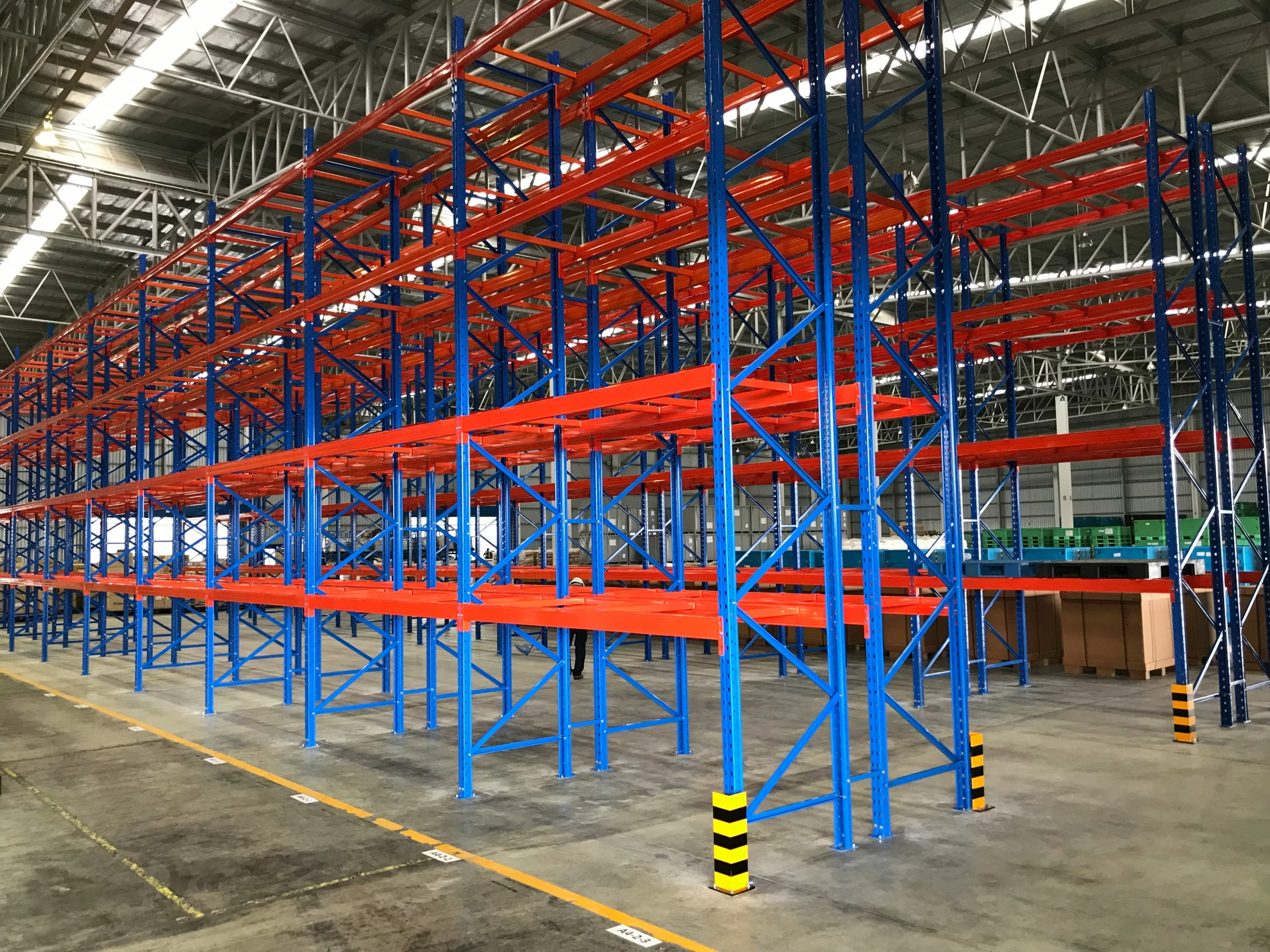 a large warehouse has many rackes of red and blue shelving