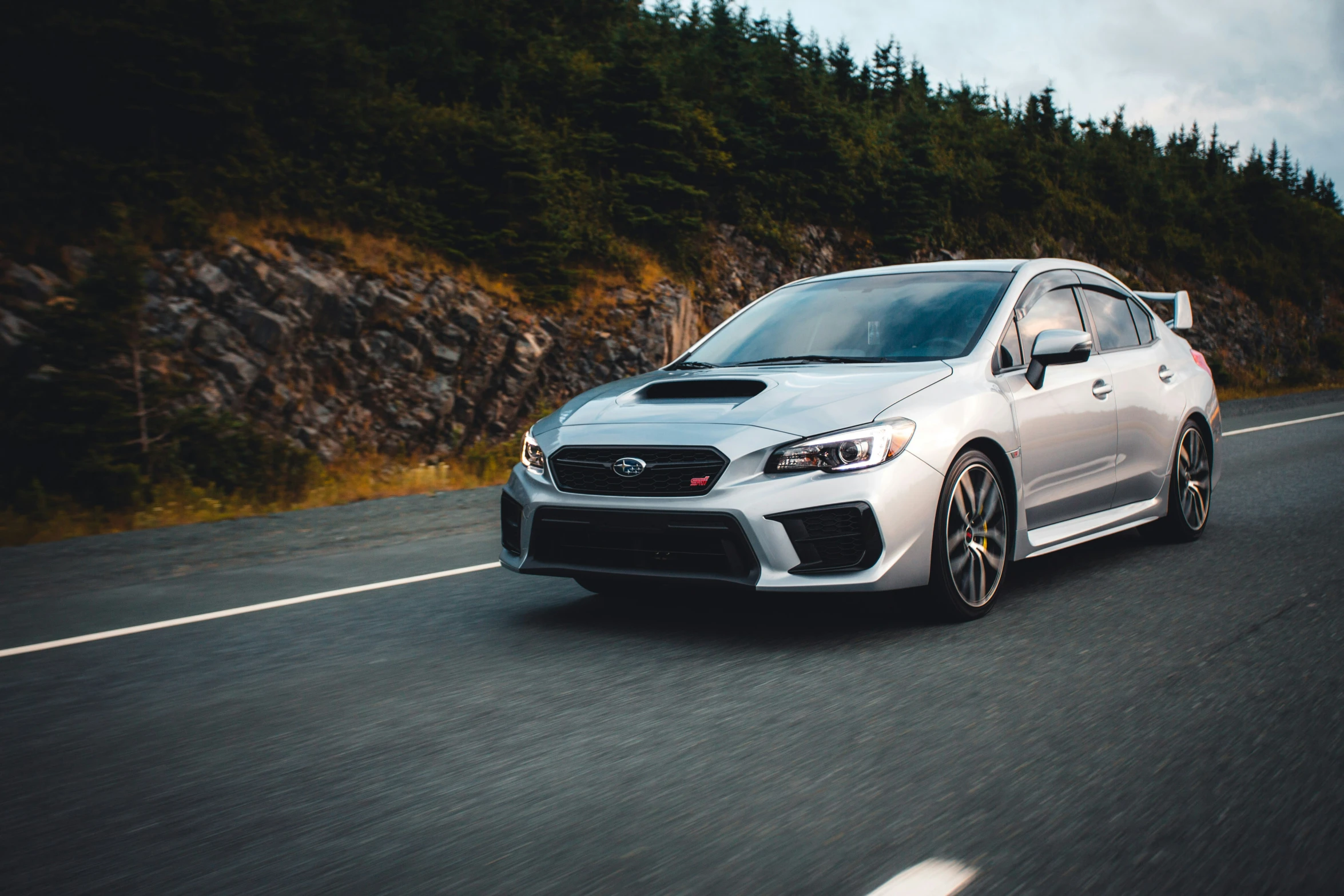 a silver subarunt is driving down the highway