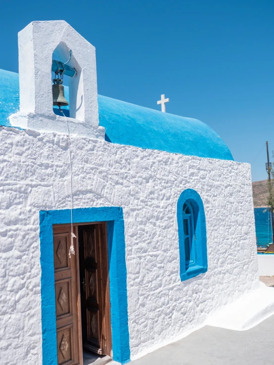 an blue and white church with bells on the roof