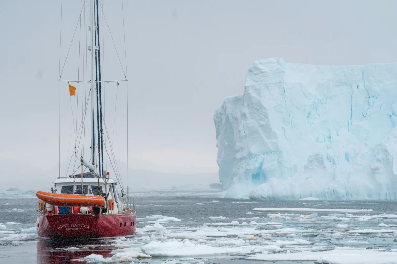 an iceberg in the background with a boat on it