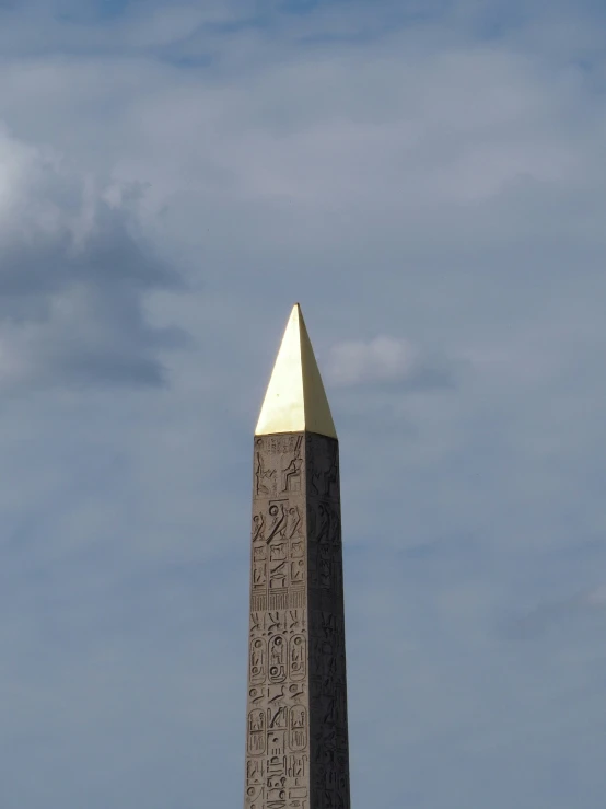 an obelisk on a stone pedestal is in a field