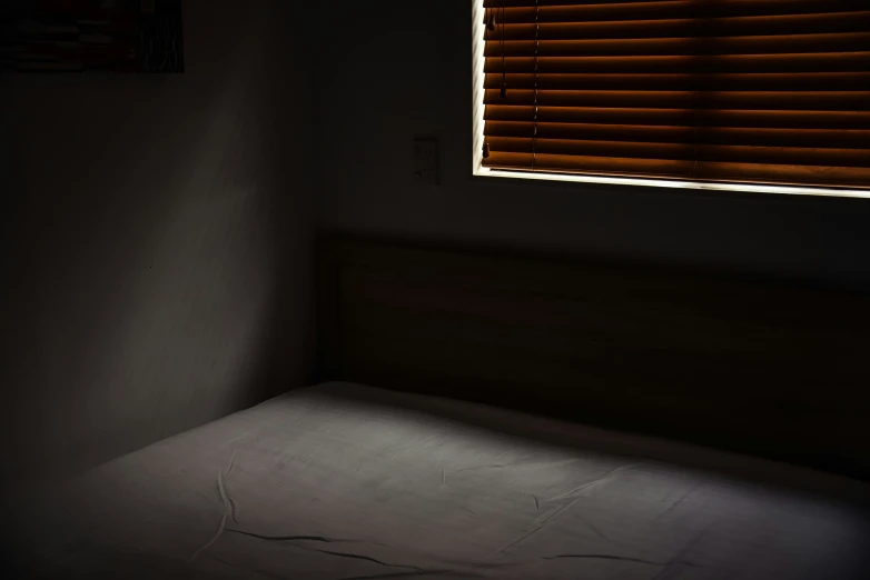 the shadow of a window shows a bed and small window