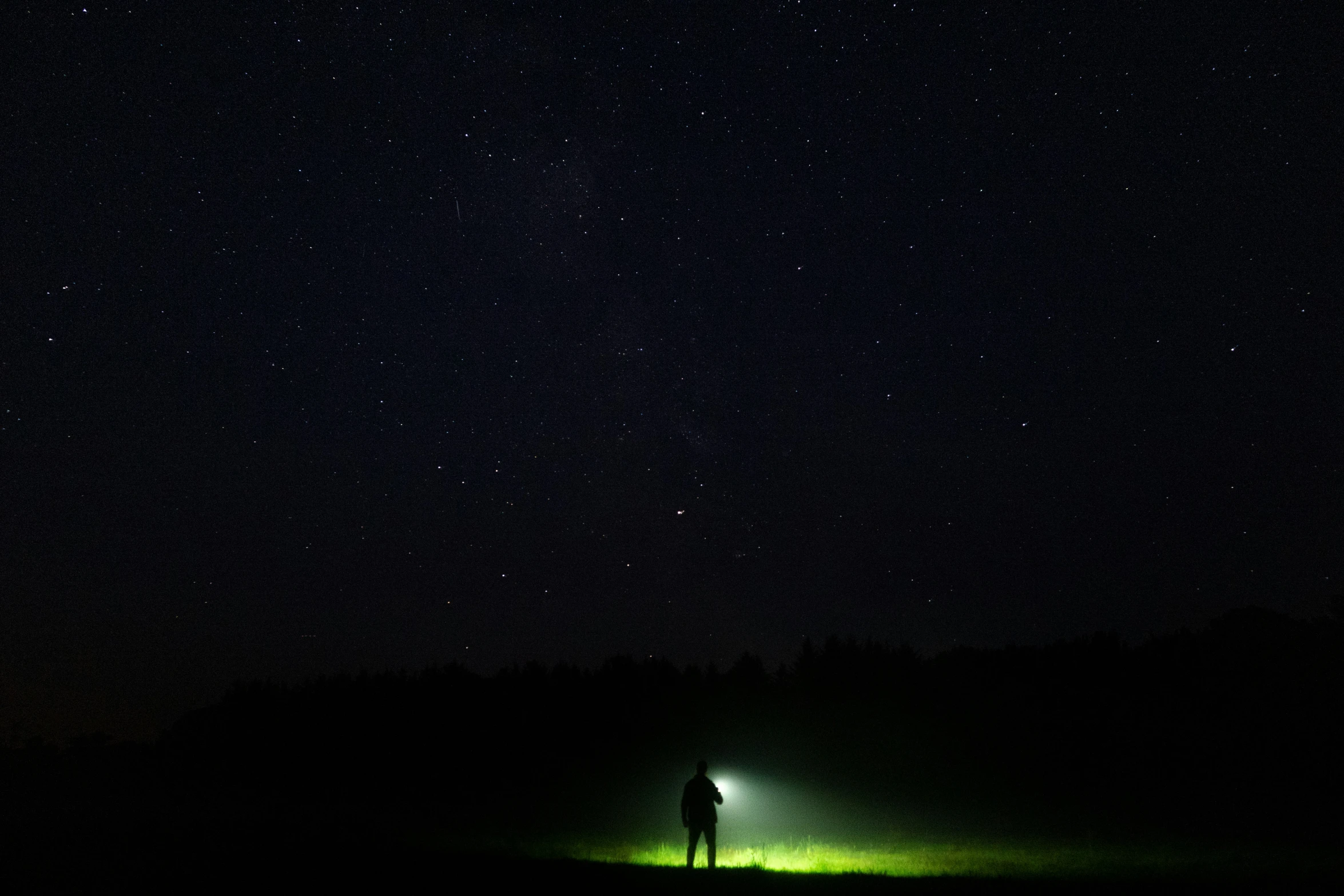 the person is standing in the field with his shadow