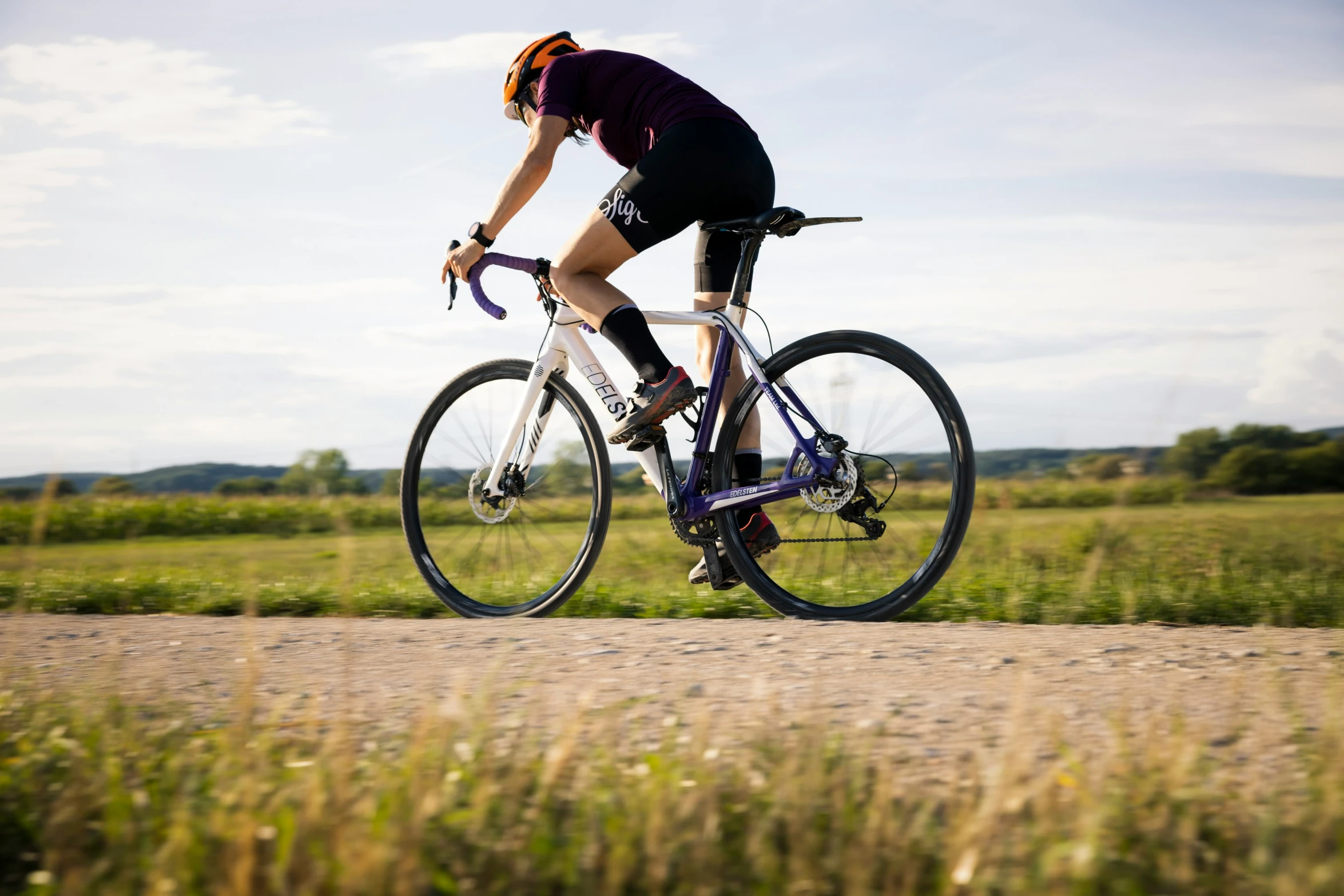 a man on his bicycle riding down a rural road