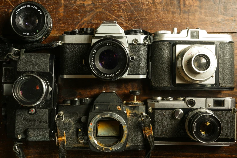 an assortment of antique cameras arranged on top of each other