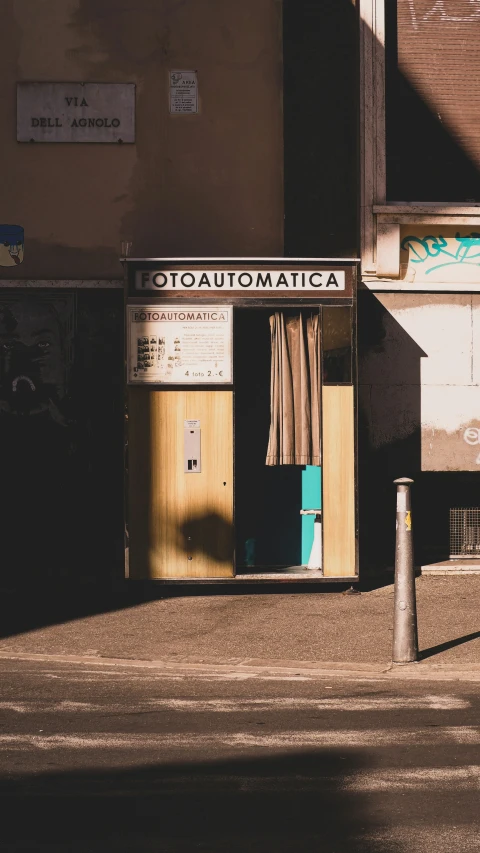 a very small public toilet in front of a building