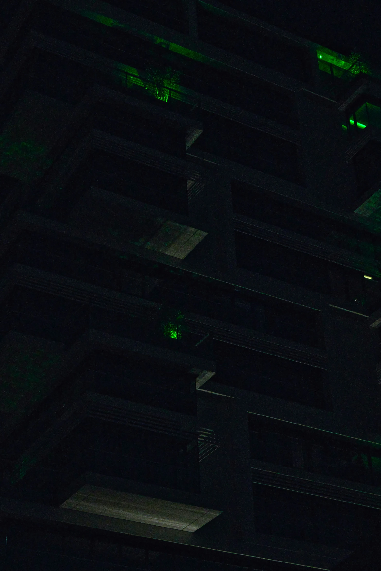 a very dark building that is lit up green