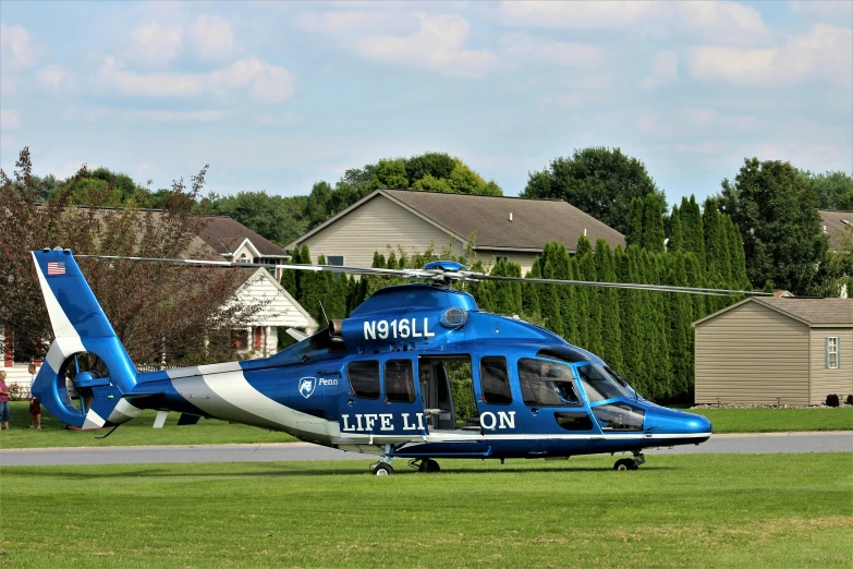 the helicopter sits on the runway in a suburban area