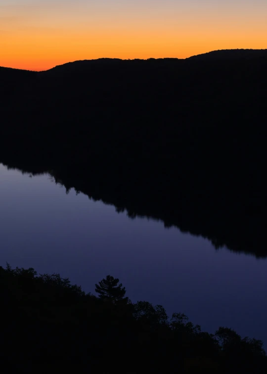 a boat floating on top of a lake at dusk