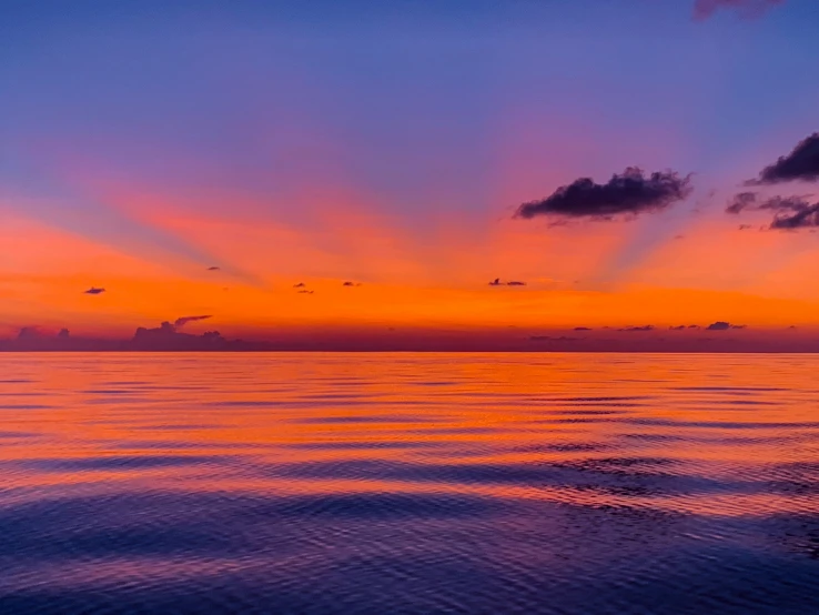 a beautiful sunset is setting over the ocean