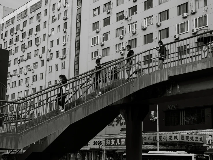 black and white image of people walking up steps in an asian city