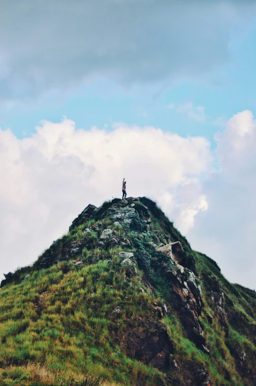 a man standing on top of a tall hill