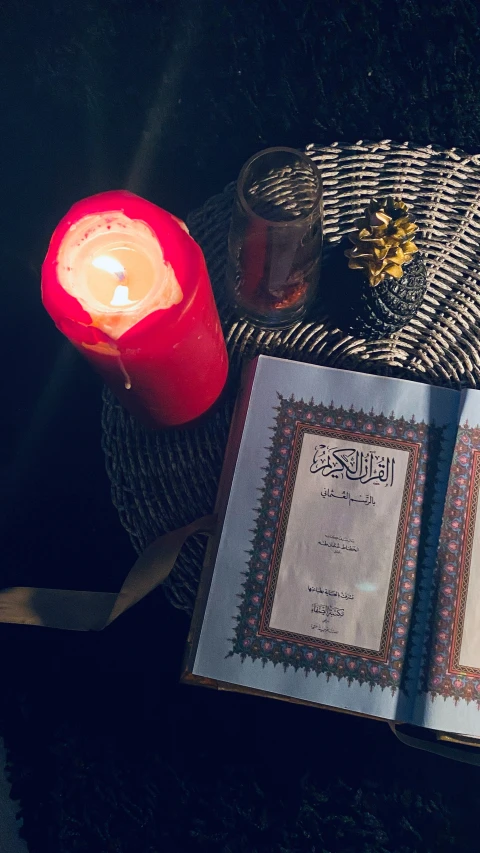 two open books sitting next to a lit candle