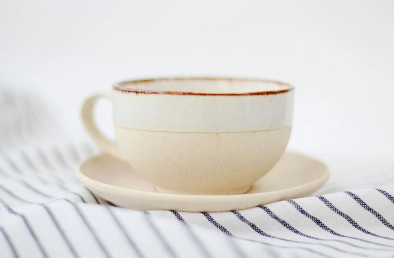 a coffee cup that has saucer and saucer on a table