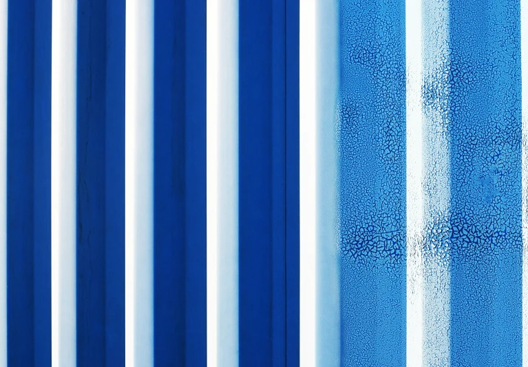 a blue and white wall with stripes that make it look like it is made of soing paper