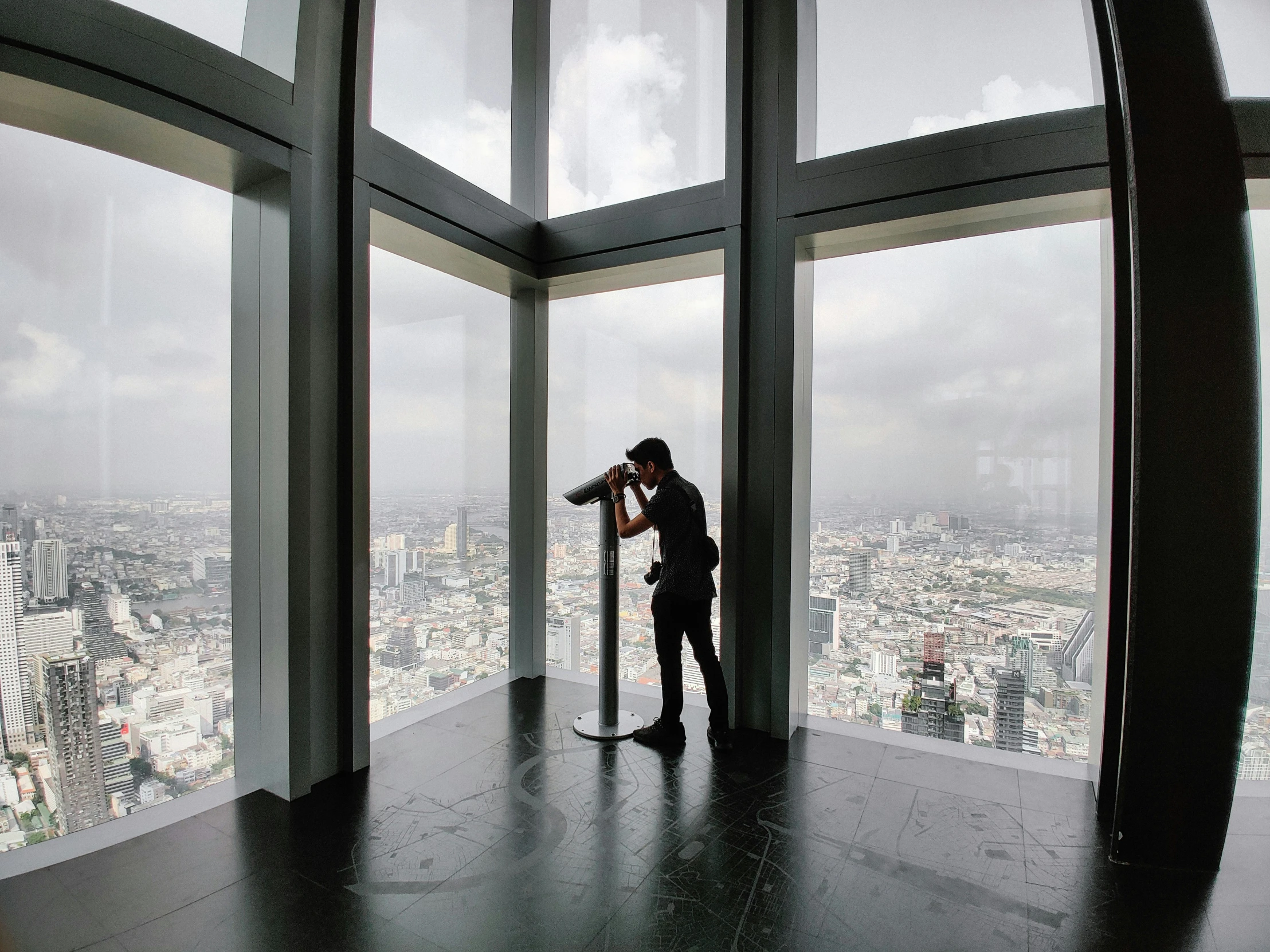 a man in a suit takes pictures from the observation deck of the shard shard