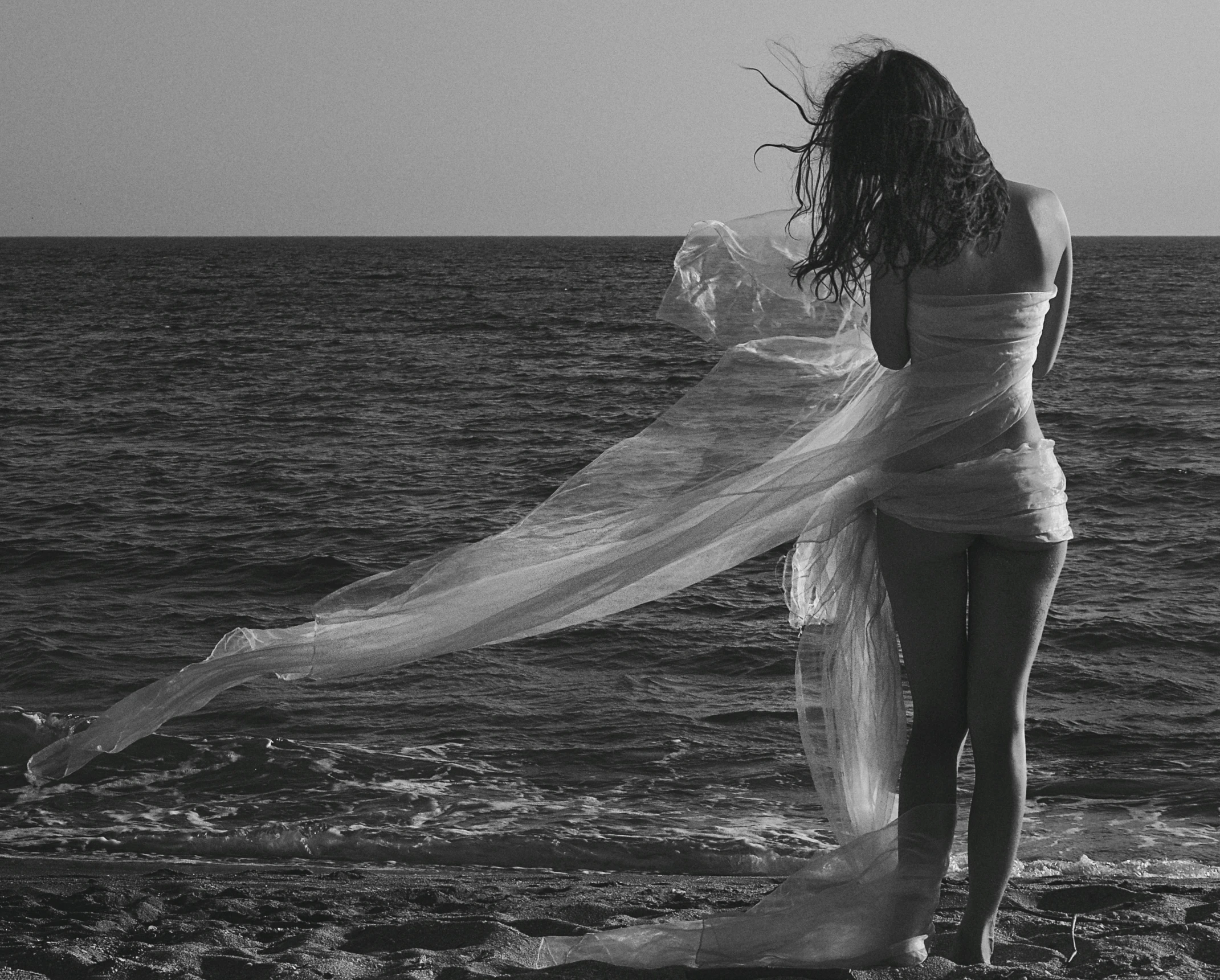 woman in white swimsuit holding up an umbrella while walking on water