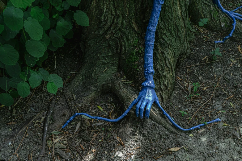 blue monster hands are attached to a tree trunk