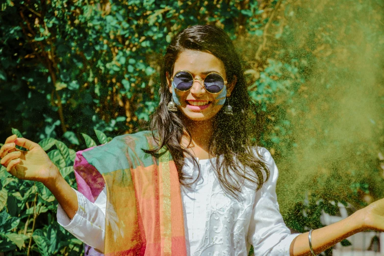 a woman standing outdoors with green powder over her eyes