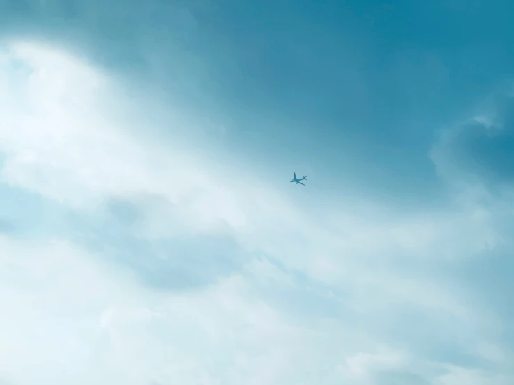 a plane flying thru the air on a cloudy day