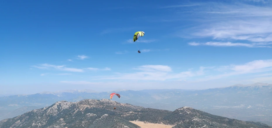 some people are para sailing in the middle of mountains